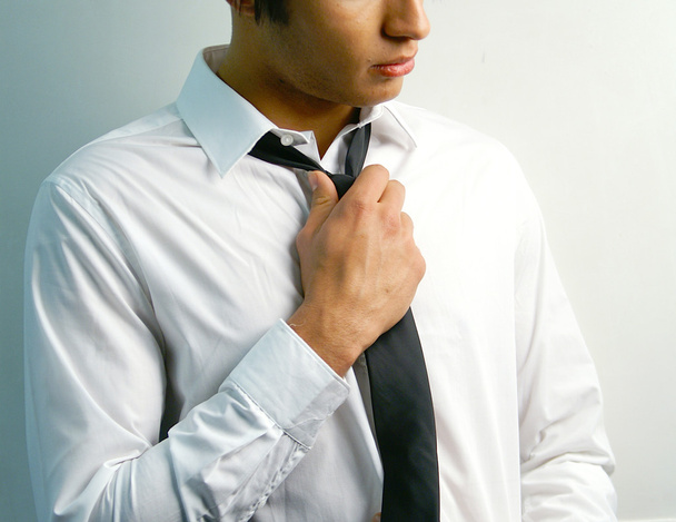 Portrait of a handsome stylish young man tie a tie - Photo, Image