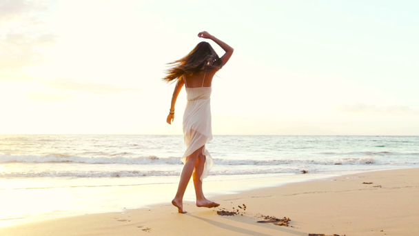 glückliches Mädchen, das sich am Strand auf der Luxusinsel bei Sonnenuntergang amüsiert. Zeitlupe - Filmmaterial, Video