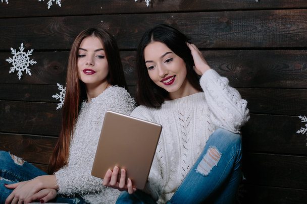 Duas meninas bonitas com um tablet, entre presentes
 - Foto, Imagem