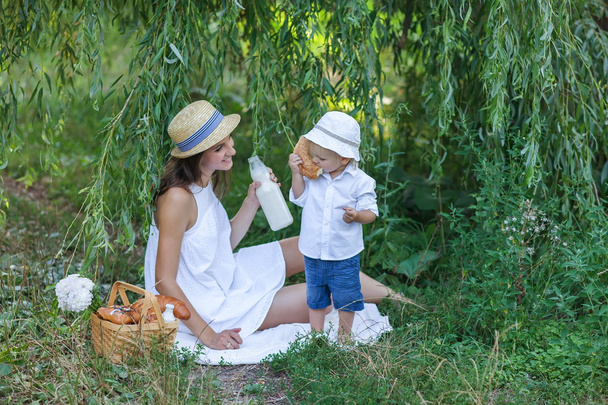 Woman and her son having picnic in summer park - Fotoğraf, Görsel