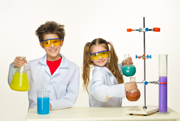 Zwei süße Kinder im Chemieunterricht beim Experimentieren - Foto, Bild