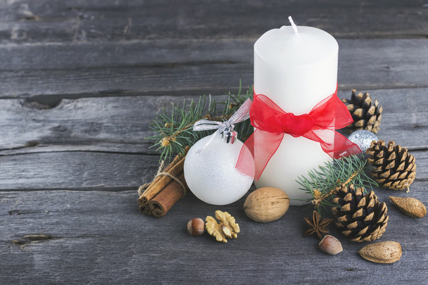 Festive candles, fir-tree, pine cones, nuts on a wooden backgrou - Photo, image