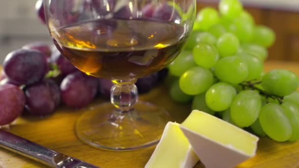 Kompozycja z kieliszek brandy winogron ser brie - Materiał filmowy, wideo