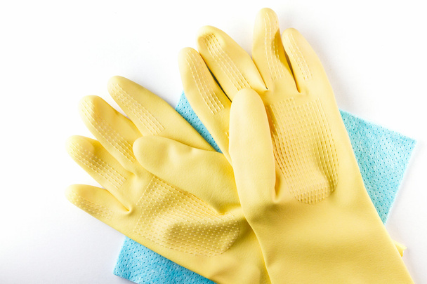 Желтые резиновые перчатки лежат на синих салфетках
. - Фото, изображение