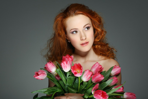 Beautiful young redheaded girl with tulips - Foto, afbeelding