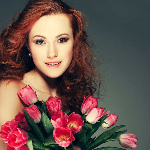 Beautiful young redheaded girl with tulips - Photo, Image