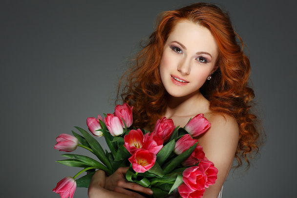 Beautiful young redheaded girl with tulips - Zdjęcie, obraz