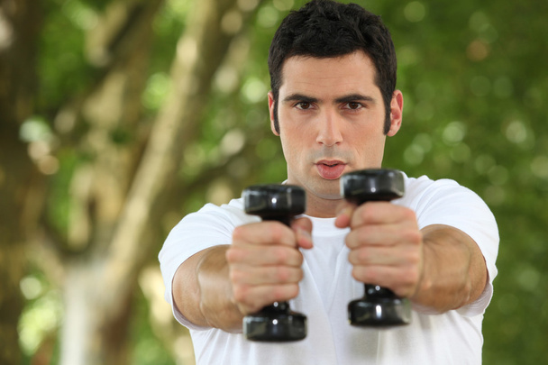 Young man doing fitness in a park - Foto, imagen