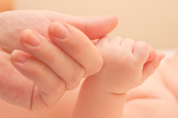 Μωρό κρατώντας το χέρι μητέρες.  - Φωτογραφία, εικόνα
