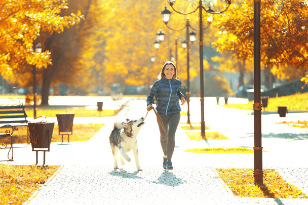Woman jogging with her dog in park - Zdjęcie, obraz