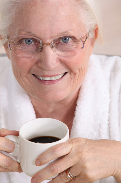 Portrait of an elderly woman drinking coffee - Foto, Imagen