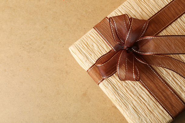 Beautiful gift with bow on wooden background - 写真・画像