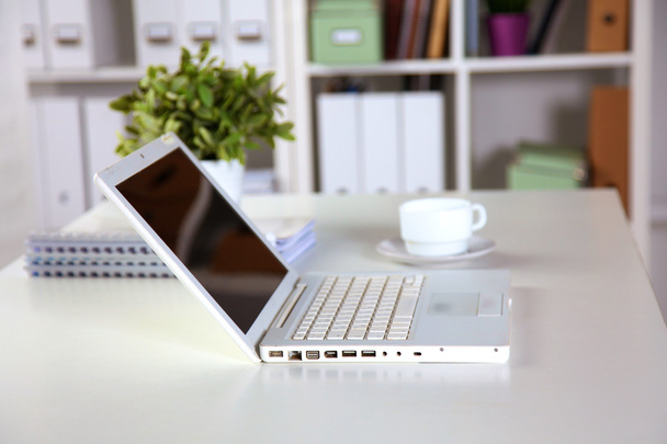Mesa de escritório com bloco de notas em branco e laptop
 - Foto, Imagem