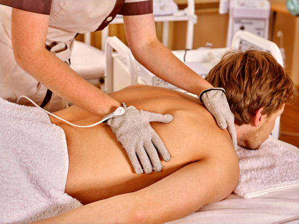 man receiving back electric massage - Photo, Image