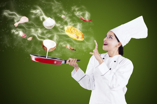 Attractive chef cooking with magic - Foto, afbeelding