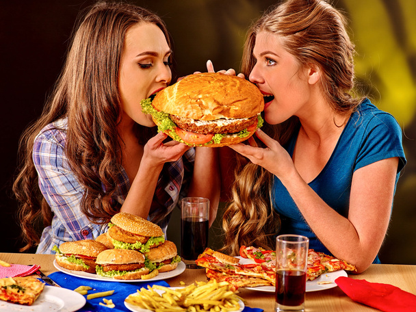 Meninas comendo sanduíche grande
 - Foto, Imagem