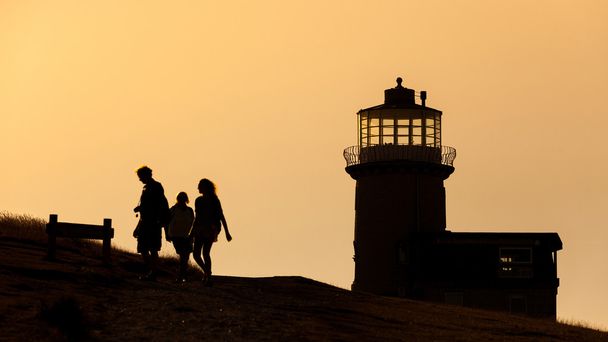 Silhouette of some people and a lighthouse in England - Fotó, kép