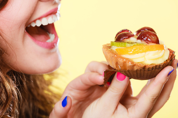 Closeup woman eating fruit cake sweet food - Foto, imagen