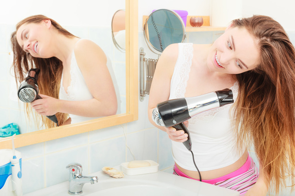long haired woman drying hair in bathroom - Fotó, kép