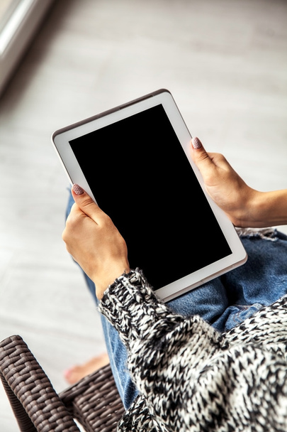 woman holding and using tablet with empty screen, ripped jeans - Foto, Imagen