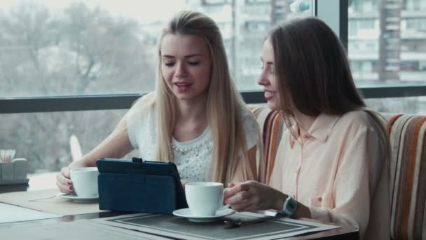 Het meisje toont aan de vriendin iets op het touchpad - Video