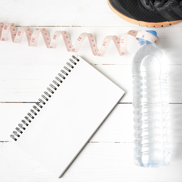 running shoes,measuring tape,drinking water and notebook  - Фото, изображение