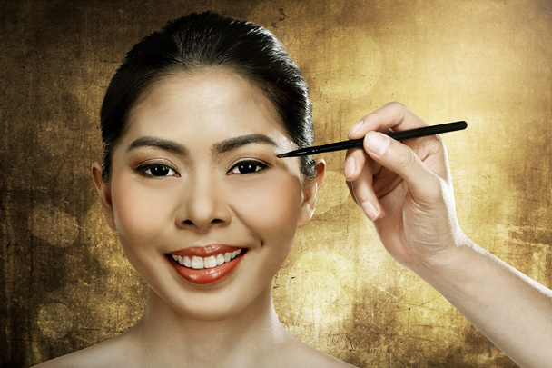 Beautiful asian woman doing makeup - Фото, изображение