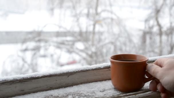 Męskiej strony wprowadzenie filiżankę kawy na starego śniegu objętych parapet - Materiał filmowy, wideo