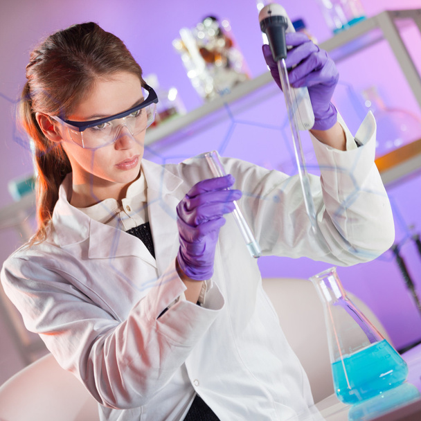Attractive young scientist pipetting. - 写真・画像