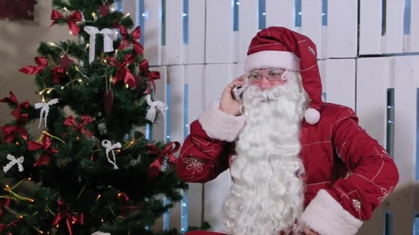 Santa Claus Is Sit and Talking His Phone, Room with Fireplace and Christmas Tree, Gifts. - Filmagem, Vídeo