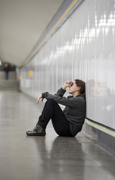 young sad woman in pain alone and depressed at urban subway tunn - Foto, afbeelding