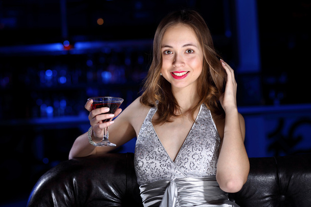 Young woman in night club with a drink - Photo, Image