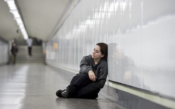 joven triste mujer en el dolor solo y deprimido en metro urbano túnel suelo preocupado sufrimiento depresión
 - Foto, Imagen