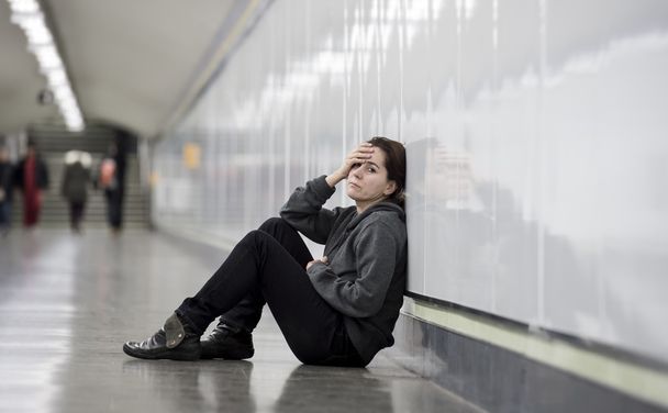 young sad woman in pain alone and depressed at urban subway tunn - Foto, afbeelding