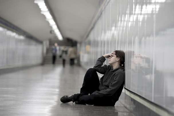 giovane donna triste nel dolore solo e depresso a metropolitana urbana terra preoccupato sofferenza depressione
 - Foto, immagini