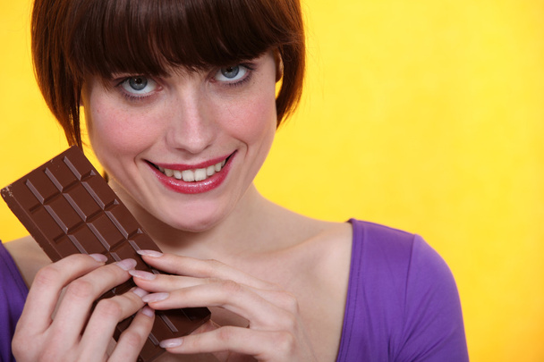 Woman with a bar of chocolate - Foto, Imagen