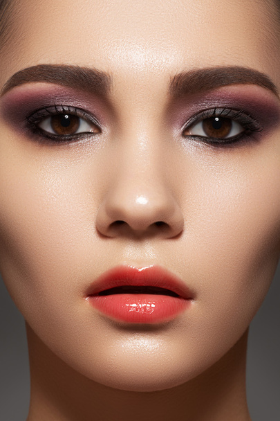 Closeup beauty portrait of attractive model face with bright visage. Purple eye makeup and gloss lips make-up - Fotoğraf, Görsel