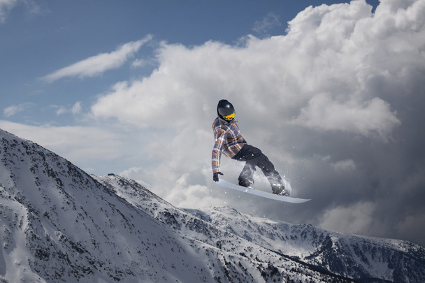 山の上を飛んでスノーボーダー。極端なスポーツ. - 写真・画像