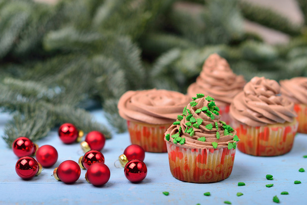 Cupcakes mit Schokoladencreme auf blauem Holzhintergrund mit r - Foto, Bild