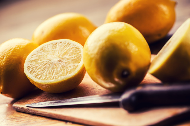 Lemons cut into the old kitchen board with mint leaves - Zdjęcie, obraz