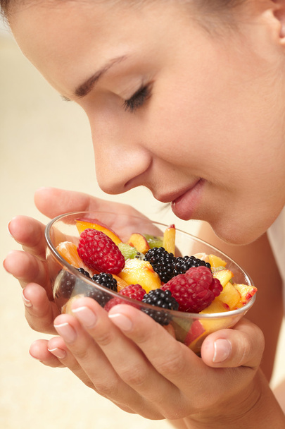 Woman eating fruit salad - Фото, изображение