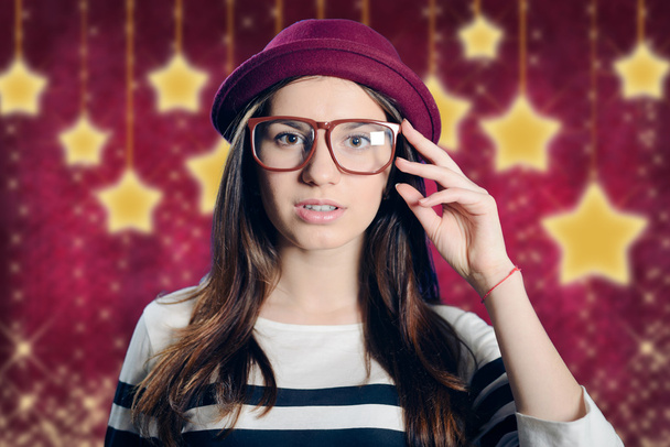 Young attractive lady in hipster glasses on starry purple background - Fotoğraf, Görsel