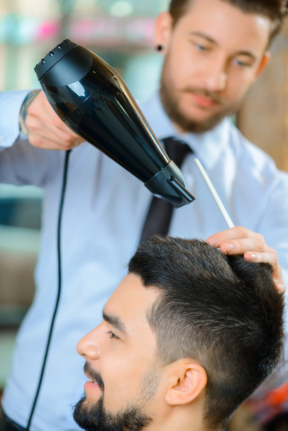 professioneller Friseur trocknet die Haare - Foto, Bild