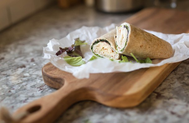 een gezonde wrap met Turkije, Groenen en kaas gemaakt met volkoren tortilla wrap - Foto, afbeelding