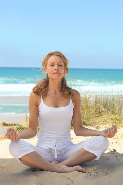 Woman meditating on the beach - Foto, immagini