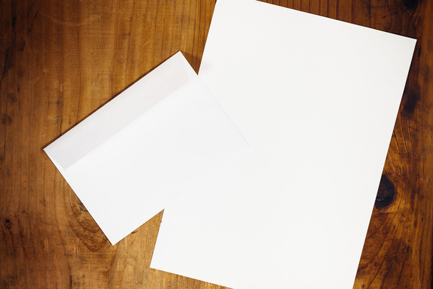 Blank white envelope and paper on wooden desk - Foto, immagini