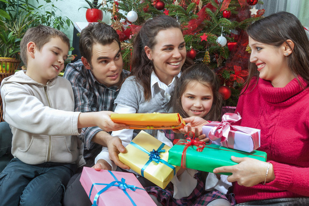 Οικογενειακή ανταλλαγή δώρων μπροστά από το χριστουγεννιάτικο δέντρο - Φωτογραφία, εικόνα