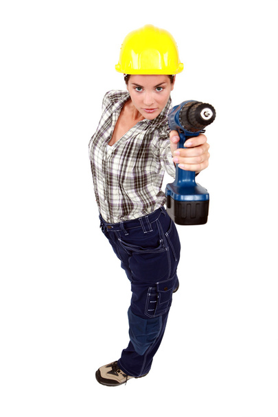 A female construction worker using a drill as a gun. - Φωτογραφία, εικόνα