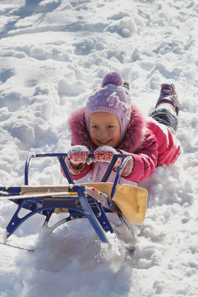 Cheerful child on a sled - 写真・画像
