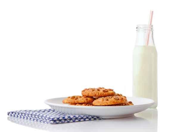 Homemade peanut butter cookies on white ceramic plate on blue napkin and bottle of milk with straw - Fotoğraf, Görsel